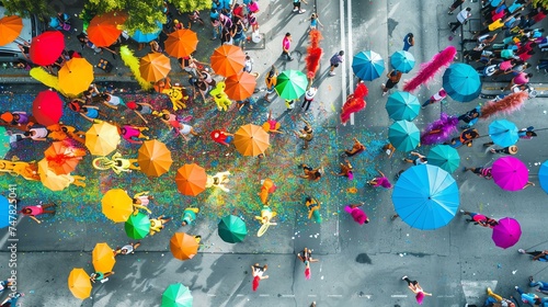 A top view of a crowd of people walking down a street during a parade. The people are wearing colorful costumes and carrying umbrellas.