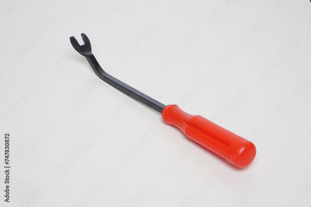 rivet screwdriver made of black iron with a red plastic handle from the side angle on a white background rivet screwdriver made of black iron with a red plastic handle from the side angle on a white background