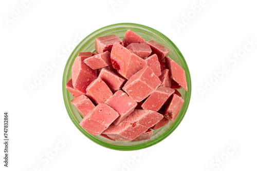 pink pieces of Uzbek dairy strawberry halva in a green bowl isolated on a white background top view