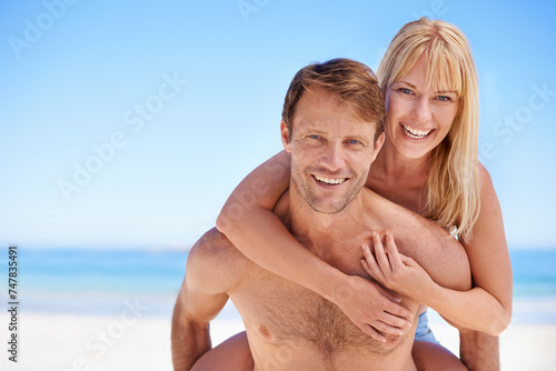 Portrait, piggyback and couple hug at a beach with support, gratitude and bonding in nature together. Travel, face and people embrace at sea with love for adventure, romance or summer fun in Jakarta