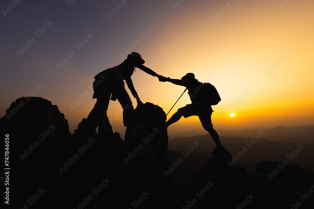 silhouette of People helping each other hike up a mountain at sunrise. Giving a helping hand, and active fit lifestyle concept. help and success concept,  Leadership Concept, teamwork. - obrazy, fototapety, plakaty 