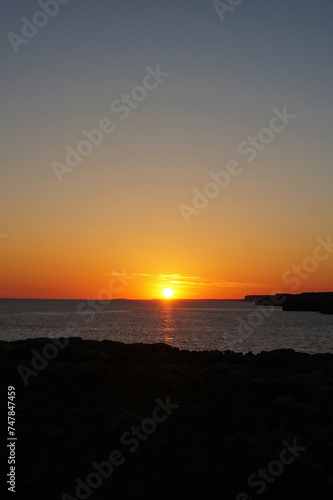 Natural landscape of Playa de Cavalleria  Mercadal  in Minorca beach with sunset sky and rocky seashore- Menorca  Spain