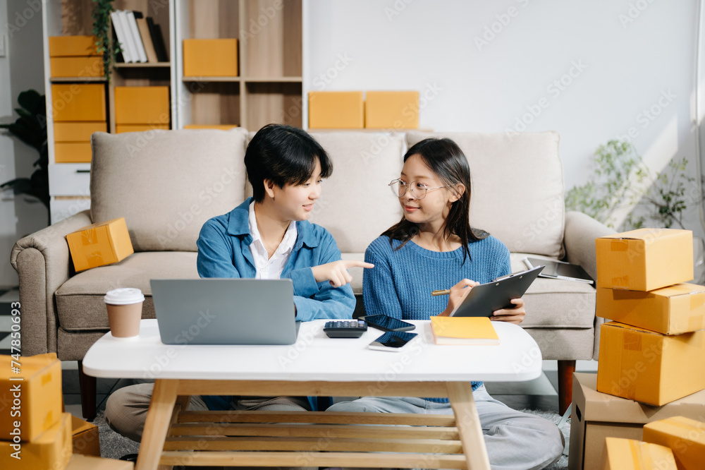 Fashion blogger concept, Two Asian women selling clothes on video streaming.Startup small business SME, using smartphone or tablet taking receive and checking. Fashion blogger concept, Two Asian women selling clothes on video streaming.Startup small business SME, using smartphone or tablet taking receive and checking.