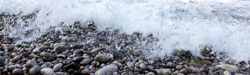 Web banner 4x1. Sea foam surf on a stone beach