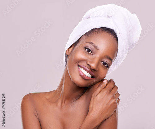 Woman, portrait and towel for skincare in studio with beauty, dermatology and self care on a white background. Face of a young model or African person with smile for hygiene, cosmetics or cosmetology
