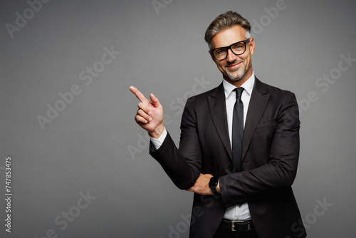 Adult fun successful employee business man corporate lawyer wear classic formal black suit shirt tie work in office point index finger aside on area isolated on plain grey background studio portrait. photo