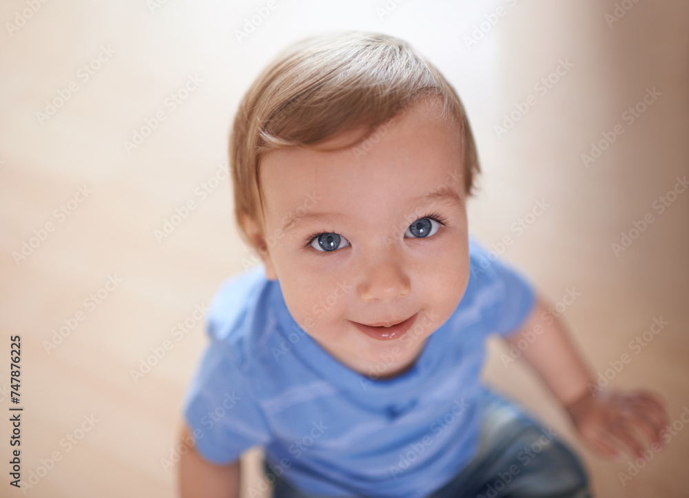 Toddler, above or portrait of baby in home for fun playing, happiness or learning in living room. Relax, boy or face of a male kid on floor with smile for child development or growth in a house alone