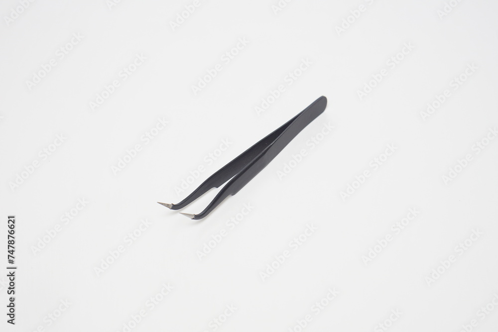 Black iron cell phone tweezers from the side on a white background Black iron cell phone tweezers from the side on a white background