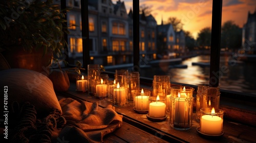 Burning candles on the windowsill. From the window there is a view of the city at night. Warm and calming atmosphere.