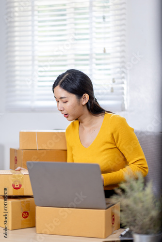 Startup small business entrepreneur SME freelance woman working with box, Young Asian small business owner office online market packing delivery, SME delivery e-commerce telemarketing seller concept © David