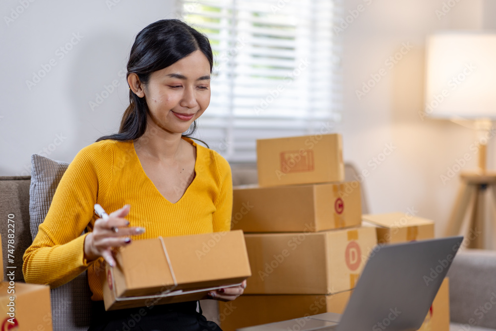 Startup small business entrepreneur SME freelance woman working with box, Young Asian small business owner office online market packing delivery, SME delivery e-commerce telemarketing seller concept Startup small business entrepreneur SME freelance woman working with box, Young Asian small business owner office online market packing delivery, SME delivery e-commerce telemarketing seller concept