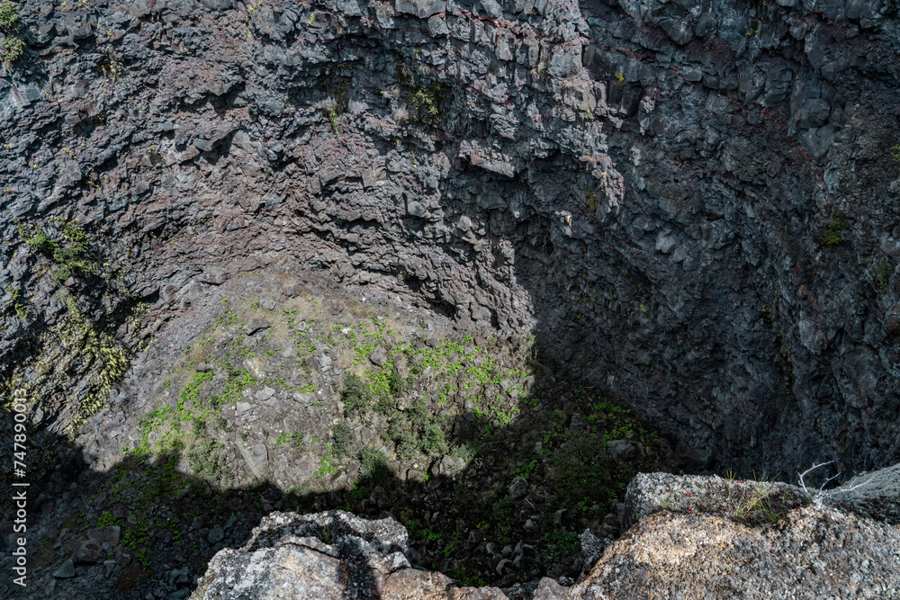 Obraz premium Devils Throat. Hawaiʻi Volcanoes National Park. Chain of Craters Rd. pit craters are depressions that form primarily as the earth fractures when a volcano shifts or expands. 