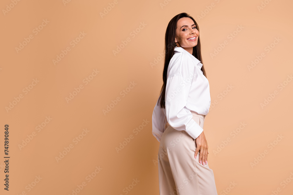 Profile portrait of lovely cheerful person toothy smile posing empty space ad isolated on beige color background Profile portrait of lovely cheerful person toothy smile posing empty space ad isolated on beige color background