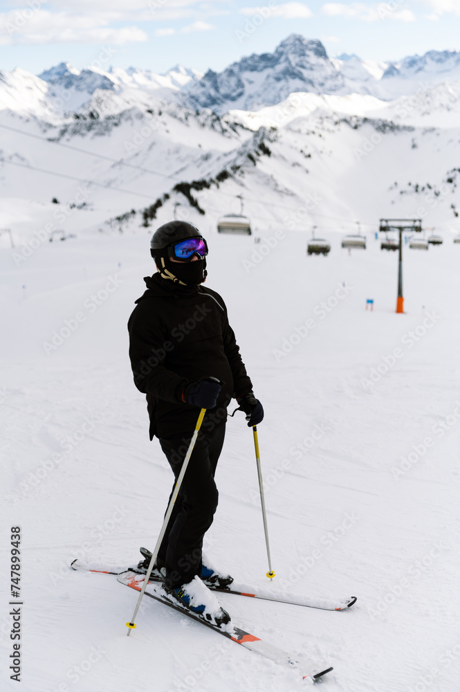 Skier in the mountains, prepared piste and sunny day. preparation for riding. vertical photo Skier in the mountains, prepared piste and sunny day. preparation for riding. vertical photo