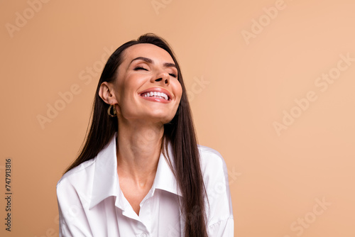 Portrait of stunning peaceful cheerful elegant lady beaming smile closed eyes empty space isolated on beige color background