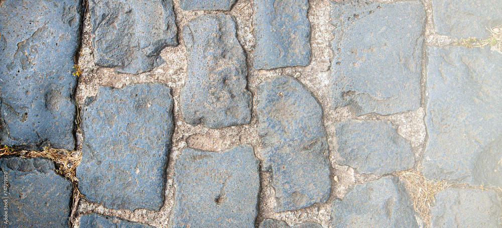 Granite cobblestoned pavement background on sunlight Granite cobblestoned pavement background on sunlight