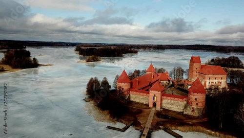 Trakai Castte Lithuania, drone shot of the medieval castle in a frozen lake on a cloudy day. panini down and towards castle. photo