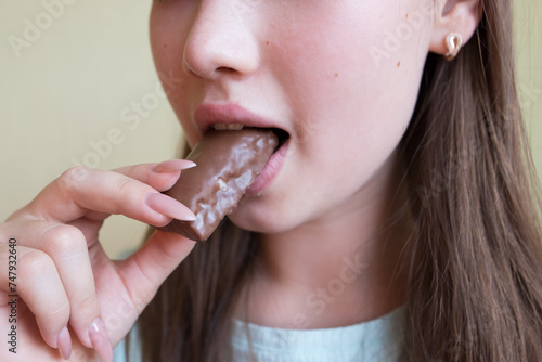 young beautiful girl eating chocolate  close-up