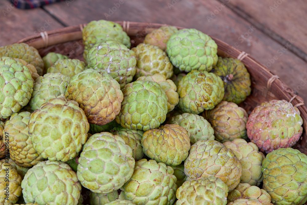 Group of ripe custard apple fruit in bamboo tray Group of ripe custard apple fruit in bamboo tray