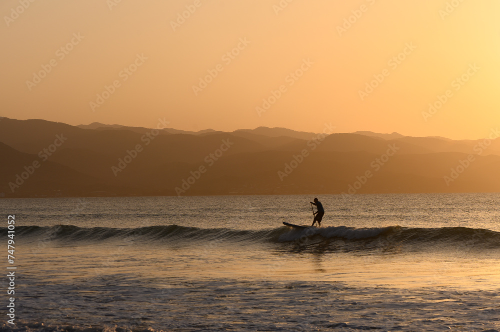SUP boarding lesson on the Mediterranean sea in winter at sunset 2