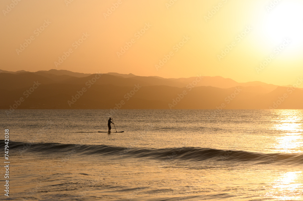 SUP boarding lesson on the Mediterranean sea in winter at sunset 4