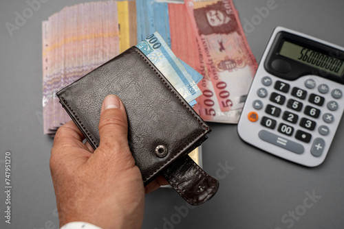 A man puts Hungarian forints in his wallet. The man holds Hungarian money on the table and in his hand. Concept showing the Hungarian economy