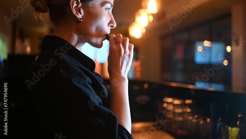 Close up side view of woman vaping and exhaling smoke photo
