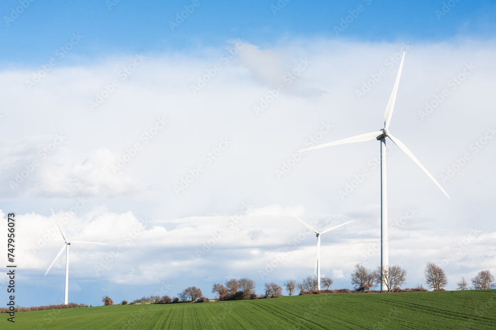 Several wind turbines protruding from green meadows. green energy. wind power.