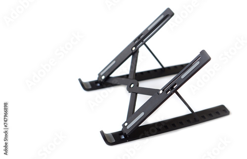 Black metal stand for placing computer laptop  tablet or mobile phone. White background. Concept  equipment to support of put screen or monitor to proper with eyesight level.           