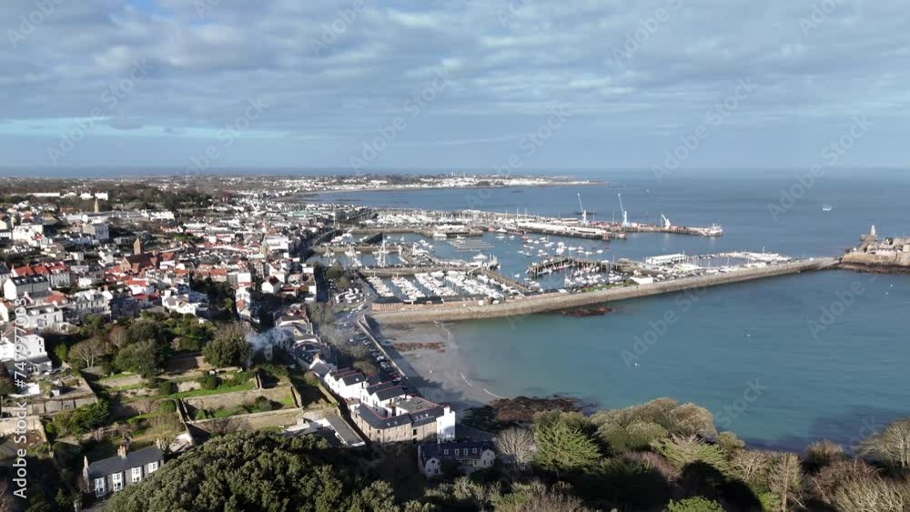 St Peter Port Guernsey flight tracking seafront from Havelet Bay, showing Castle Breakwater and marinas with views over Belle Greve Bay on bright sunny day with calm clear sea and blue sky St Peter Port Guernsey flight tracking seafront from Havelet Bay, showing Castle Breakwater and marinas with views over Belle Greve Bay on bright sunny day with calm clear sea and blue sky