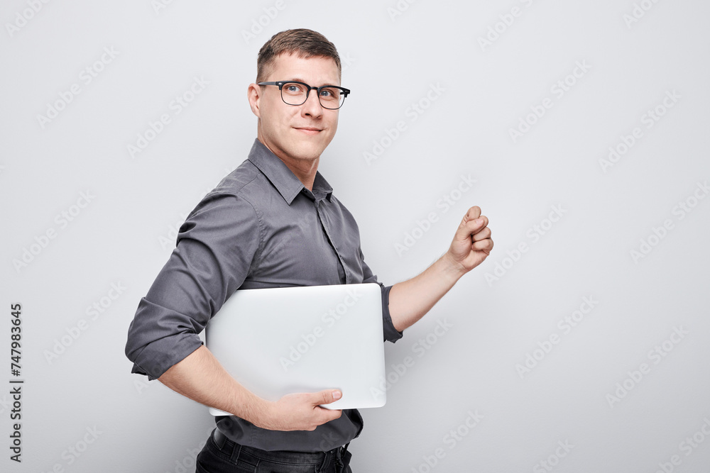 Joyful businessman manager programmer holds a laptop in his hands and smiles on a white background. Joyful businessman manager programmer holds a laptop in his hands and smiles on a white background.