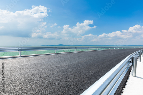 Asphalt road and lake natural landscape under blue sky