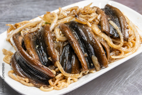 Delicious Taiwanese cuisine featuring grilled eel served on top of a plate of noodles photo