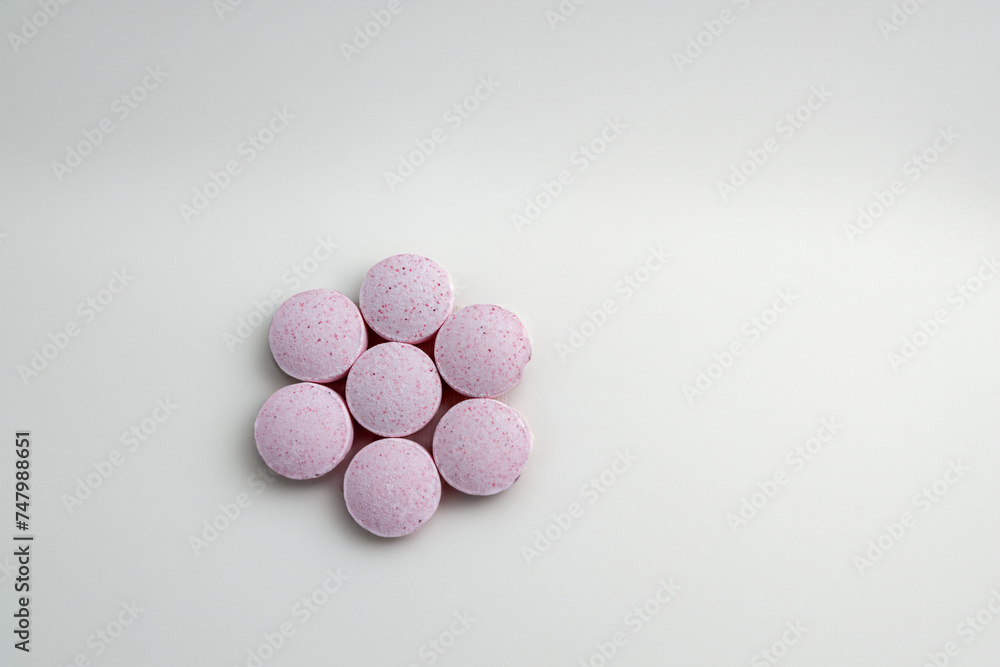 Vitamin B12 tablets arranged in the shape of a vibrant flower, standing out against a white background. Conveys a healthy and vitality concept. Vitamin B12 tablets arranged in the shape of a vibrant flower, standing out against a white background. Conveys a healthy and vitality concept.