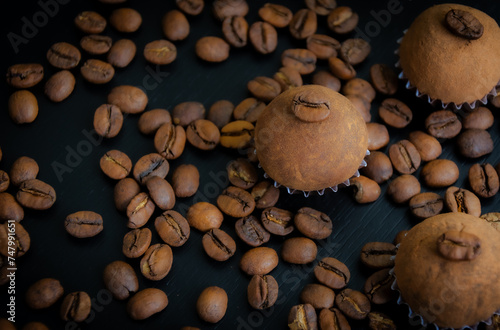 Um brigadeiro de café delicadamente disposto em uma base de forminha marrom, adornado com grãos de café, em meio a uma decoração. A coffee brigadeiro delicately arranged in a brown base.