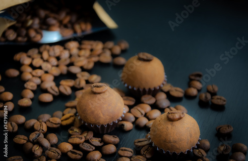 Um brigadeiro de café delicadamente disposto em uma base de forminha marrom, adornado com grãos de café, em meio a uma decoração. A coffee brigadeiro delicately arranged in a brown base.