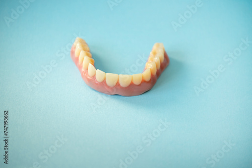 Realistic mockup of the lower jaw with teeth on a blue background.