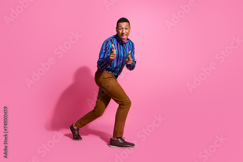 Full length photo of excited cheerful guy wear striped shirt pointing fingers you isolated pink color background