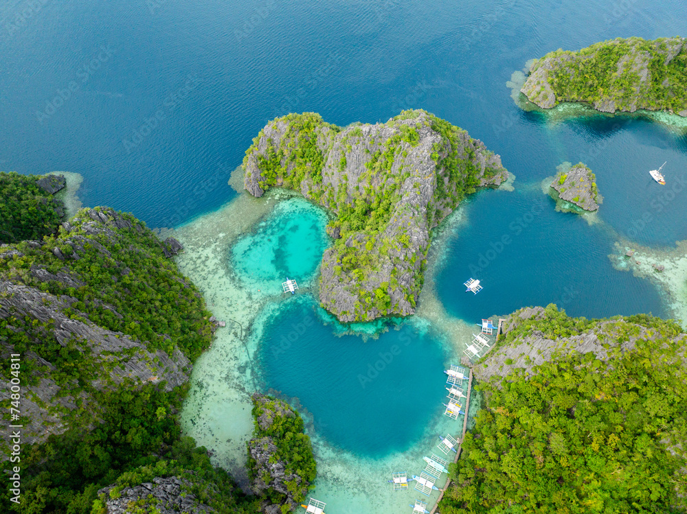 Lagoons with corals. Boats over turquoise water in Kayangan Lake. Coron, Palawan. Philippines.