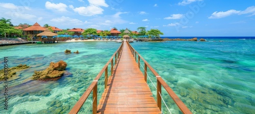 Wooden walkway leading to overwater bungalows at tropical resort with turquoise ocean water below