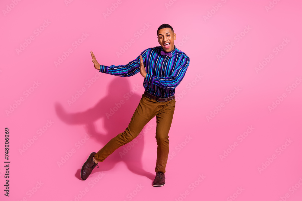 Full length photo of positive good mood guy wear striped shirt dancing disco having fun isolated pink color background Full length photo of positive good mood guy wear striped shirt dancing disco having fun isolated pink color background