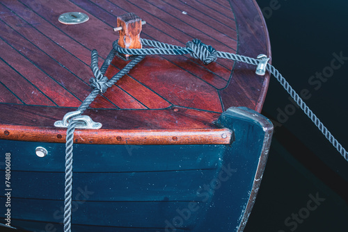 Boat anchored in water with ropes and a secure knot
