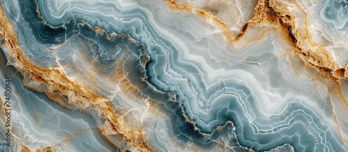 This close-up showcases the intricate pattern of a blue and gold marble against a natural background. The stunning surface of the marble reflects light  highlighting its captivating colors.