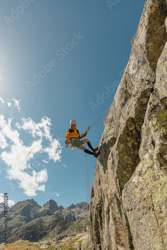 woman climbing in the mountain at sunset with lus rays, security, confidence business woman, rope access, life insurance.
