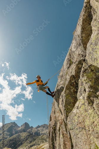 woman climbing in the mountain at sunset with lus rays, security, confidence business woman, rope access, life insurance.