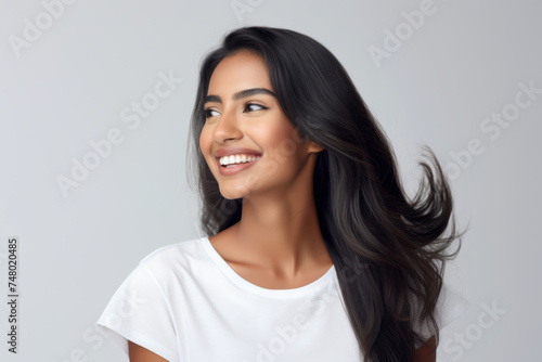 Portrait of a smiling young woman of Indian ethnicity having long flowing hair photo