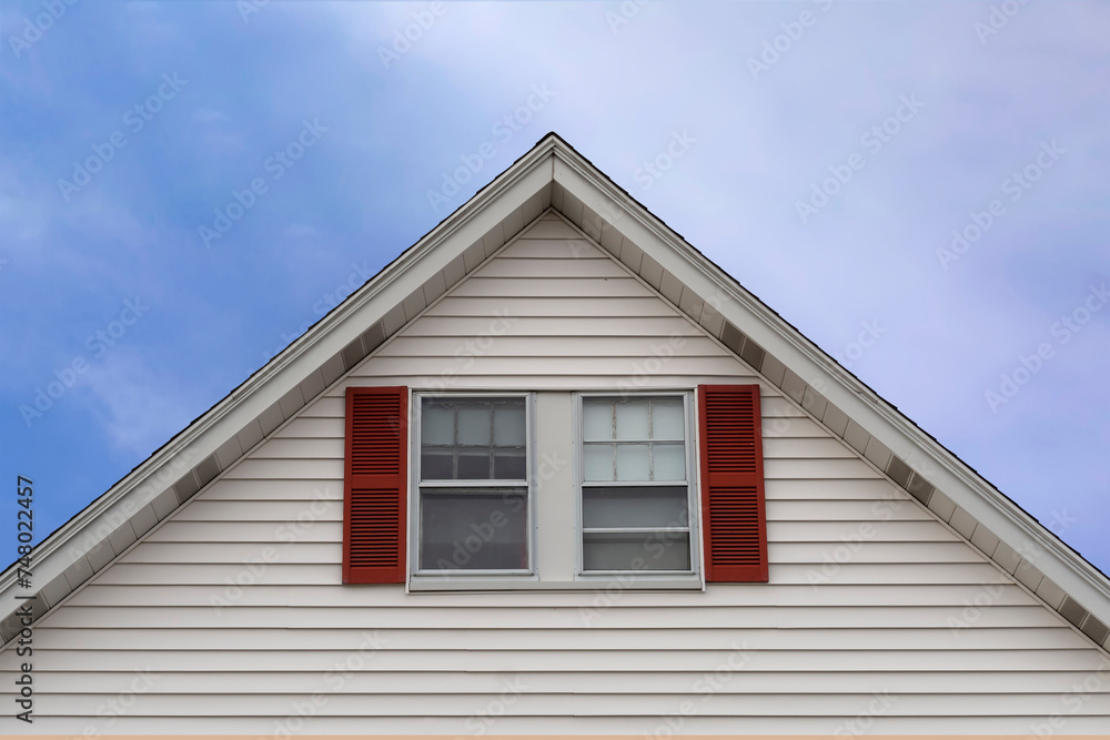 Gable end windows with fixed decorative shutters of a house in Boston, MA, USA
