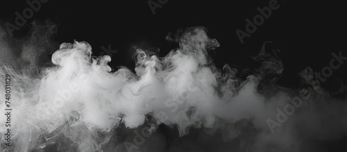 This black and white image showcases billowing smoke creating abstract patterns against a stark black backdrop. The smoke appears to have a sense of movement and depth as it disperses in the air.