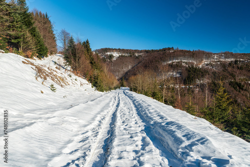 Winter scenery with snow covered road with hills above in Kysucke Beskydy mountains in Slovakia photo