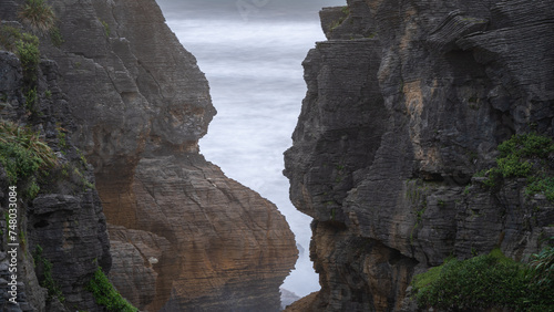 Tight detail shot on weirdly shaped exotic coastal cliffs with ocean in background, New Zealand